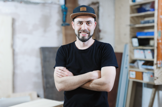 Dominik Thunig bei der Arbeit an einem massiven Holzbrett in seiner Werkstatt