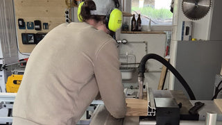 Blick in die Werkstatt: Ein Holzbrett wird an der Formatkreissäge zugeschnitten